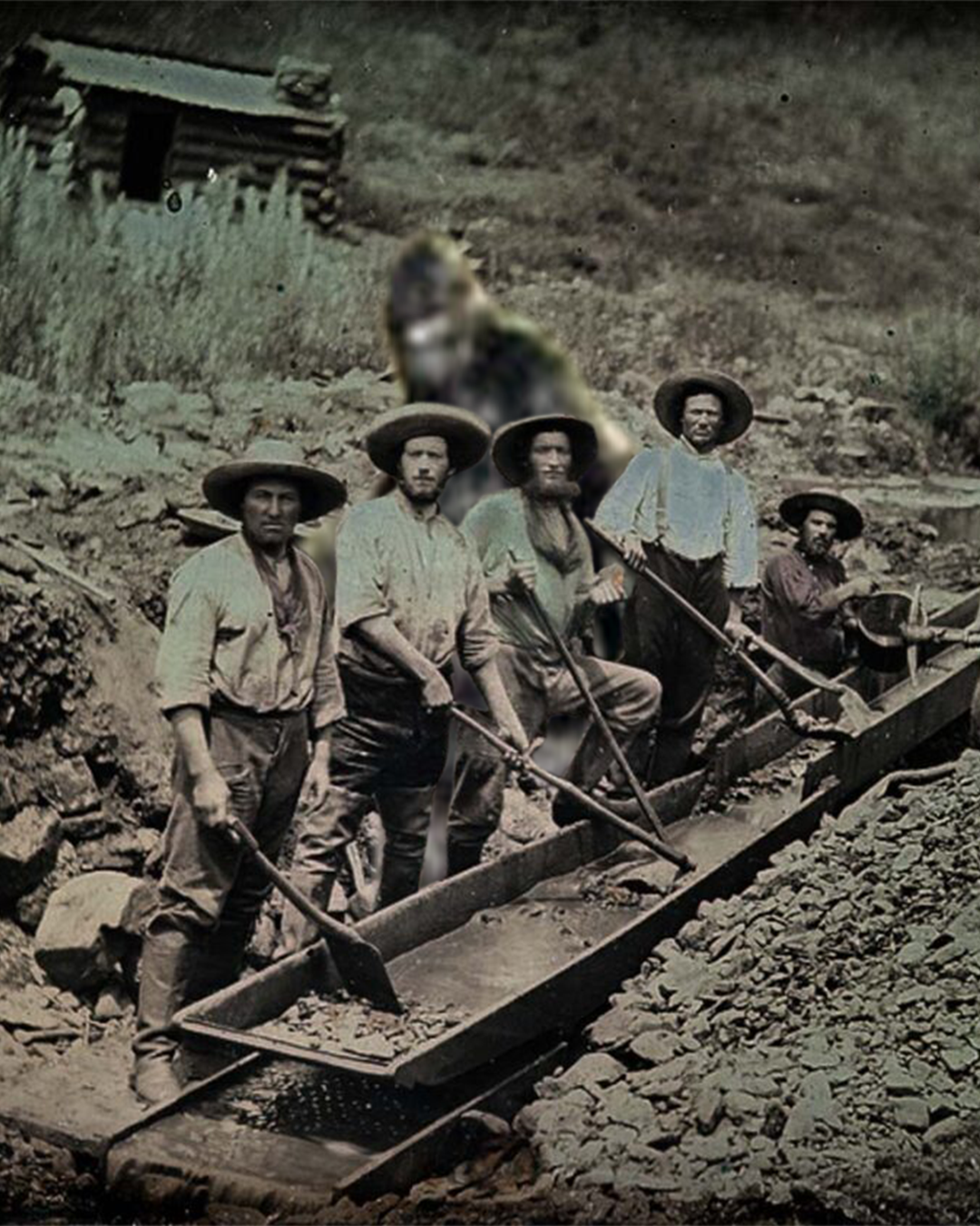 Old photo of men during the Gold Rush with Sasquatch behind them.