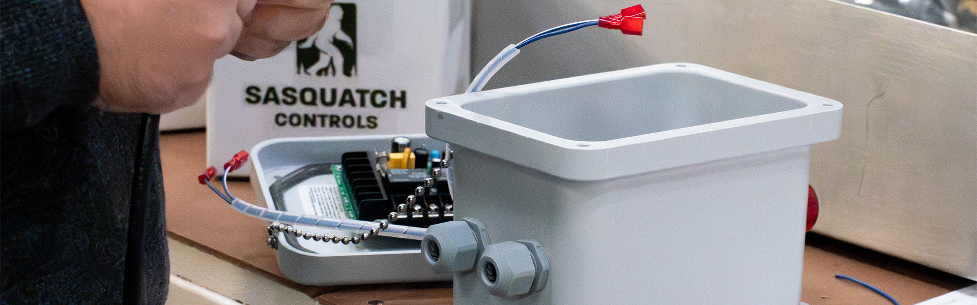 Person assembling Sasquatch Liquid Level Alarm in warehouse.